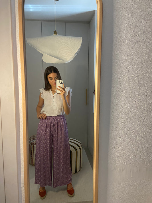 Pantalón en color lila con florecitas y elástico en cintura.  Composición: 100 % viscosa.  Hecho en Italia.  La modelo mide 163 cm.